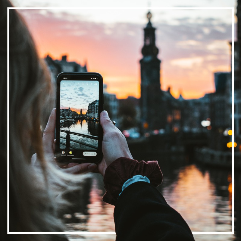 Girl taking photo in Amsterdam on her camera phone