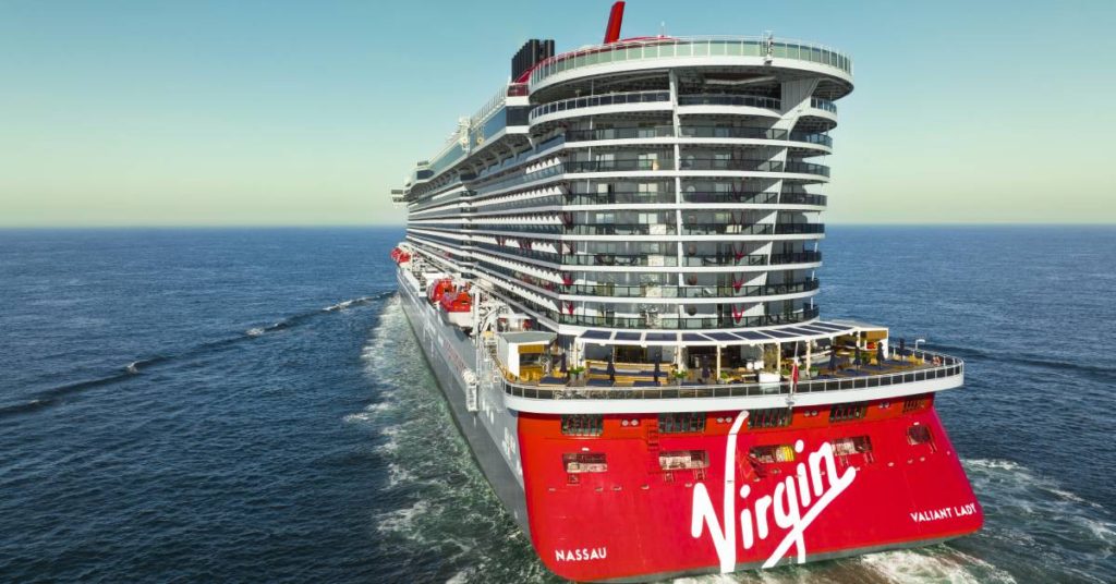 Stern view of a Virgin Voyages cruise ship with passengers on the aft sundeck