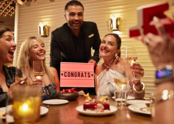 Group of friends celebrating at The Wake restaurant onboard a Virgin Voyages ship.