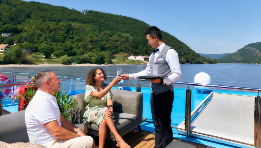 Guests reciving a drink from a waiter on AmaMagna