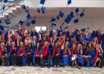 Graduating apprentices throwing caps in the air.
