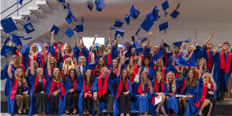 Graduating apprentices throwing caps in the air.