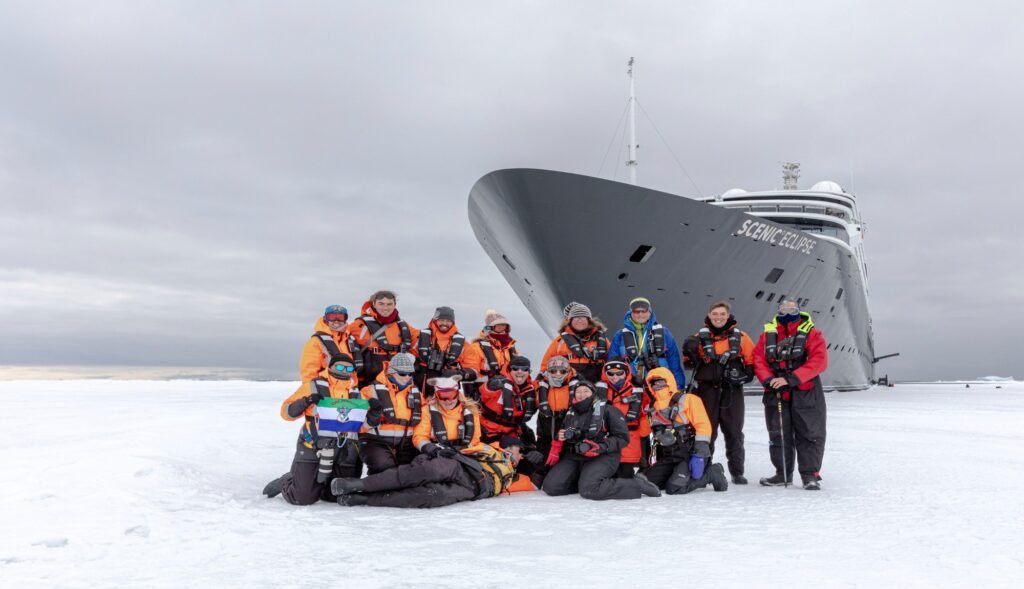 Expedition cruise passengers dressed in polar gear exploring Antarctica