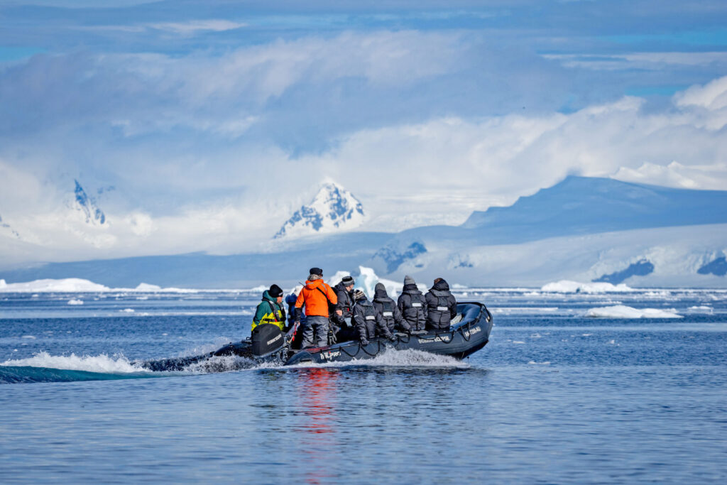 Expedition cruise passengers dressed in polar gear exploring Antarctica