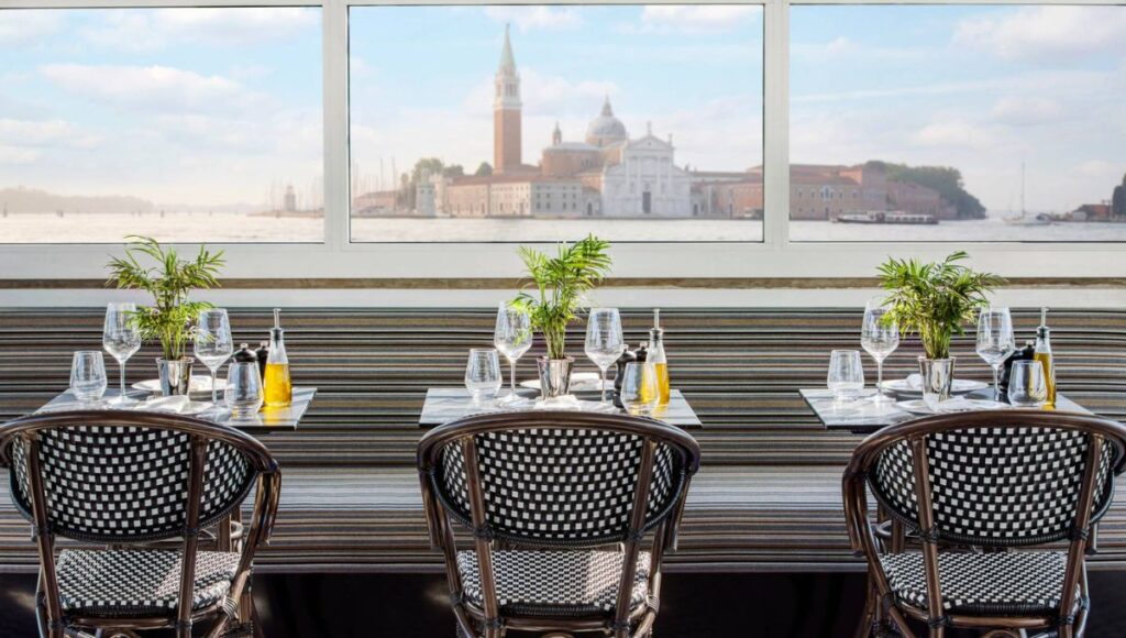 Scenic restaurant view from a luxury river cruise ship sailing through Venice lagoon