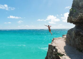 Person cliff jumping into the sea in Barbados during a Southern Caribbean cruise