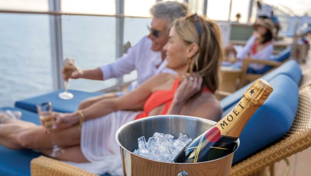 couple enjoying drinks on balcony adult only cruise experience