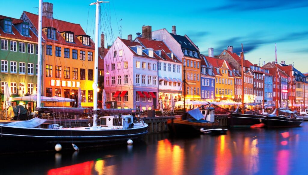 Nyhavn waterfront in Copenhagen, Denmark, with colourful historic buildings and boats.
