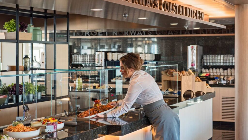 Restaurant staff serving a buffet at Norway’s Coastal Kitchen aboard a Hurtigruten ship.