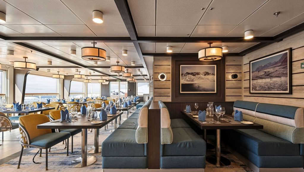 The Hut restaurant on Douglas Mawson, with booth seating and tables laid for dinner