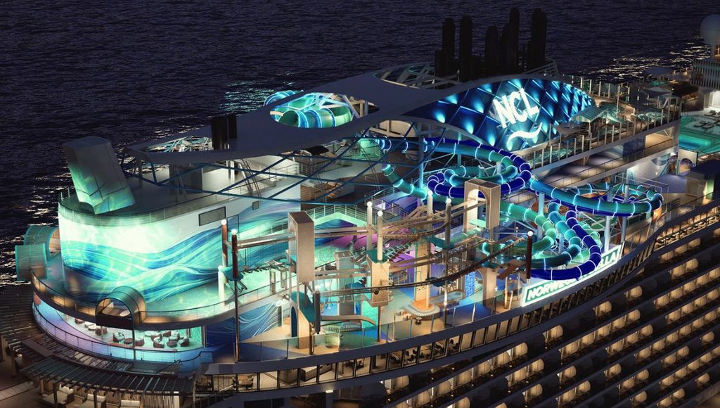 Ocean Heights lit up at night on Norwegian Bella, with illuminated waterslides and the ropes course