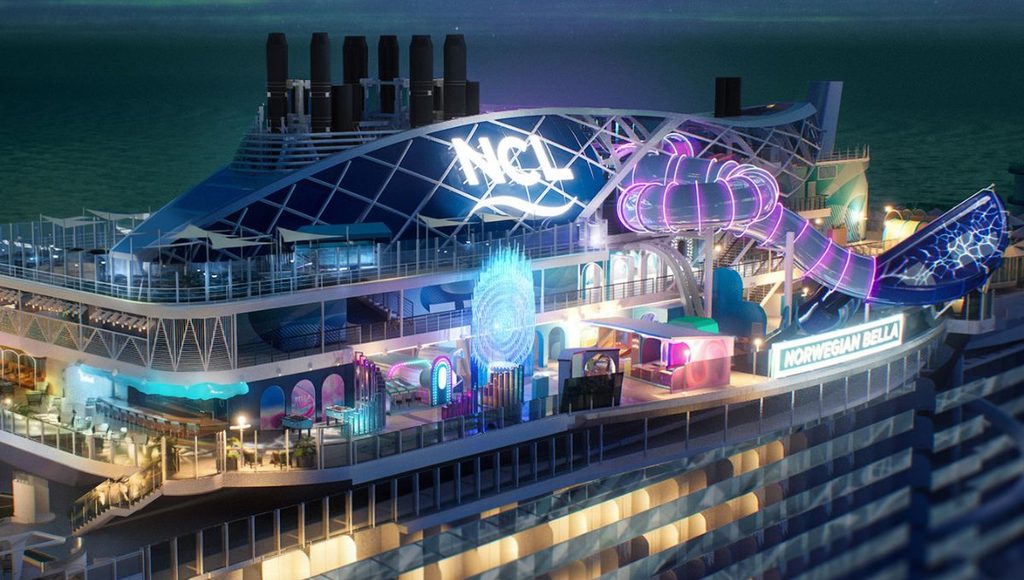 Ocean Heights at night on Norwegian Bella, with neon lit games and a glowing waterslide