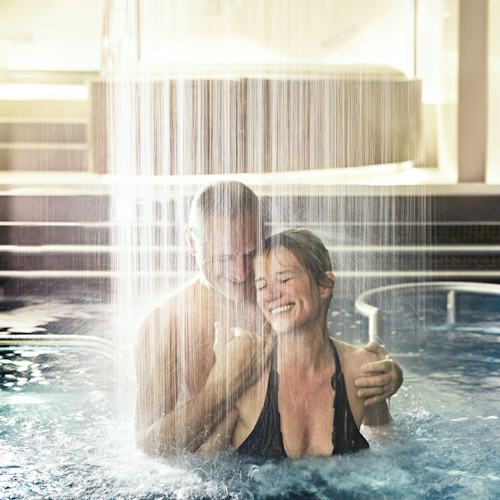 Princess Cruises - Royal Princess - The Enclave - Couple in the Lotus Spa Pool with Rain Shower Waterfall