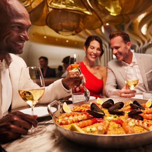 4 people enjoying paella onboard Celebrity Cruises