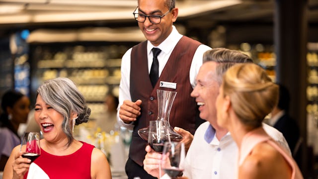 Waiter serving guests in Seabourn Venture's restaurant