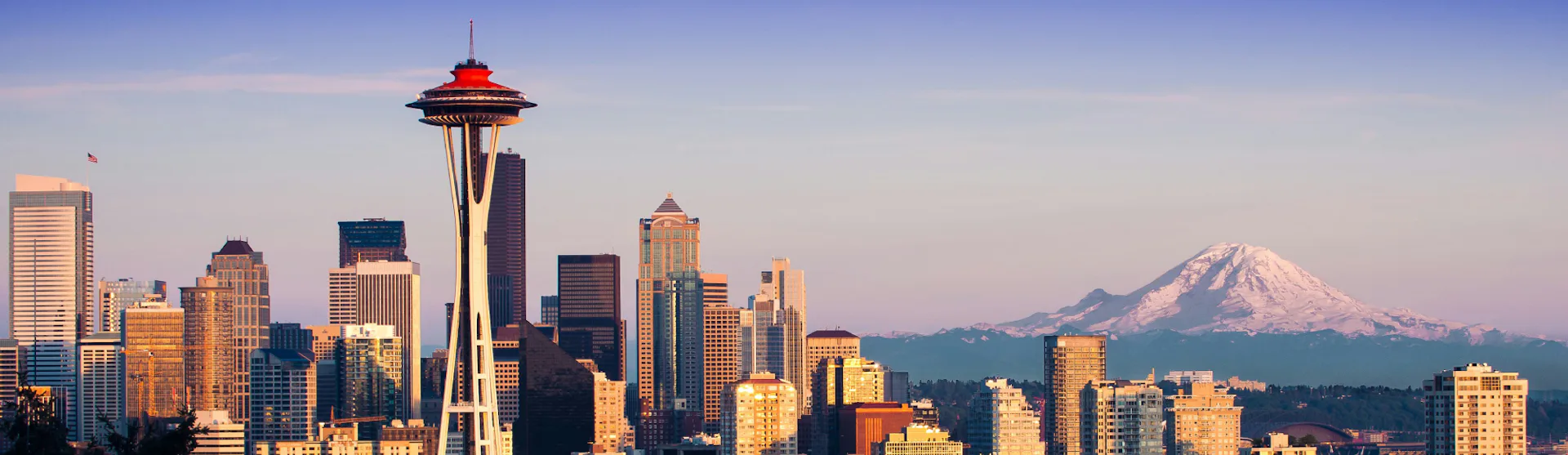 Seattle's famous skyline with Space Needle in the foreground and mountains in the background