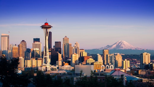 Seattle's famous skyline with Space Needle in the foreground and mountains in the background
