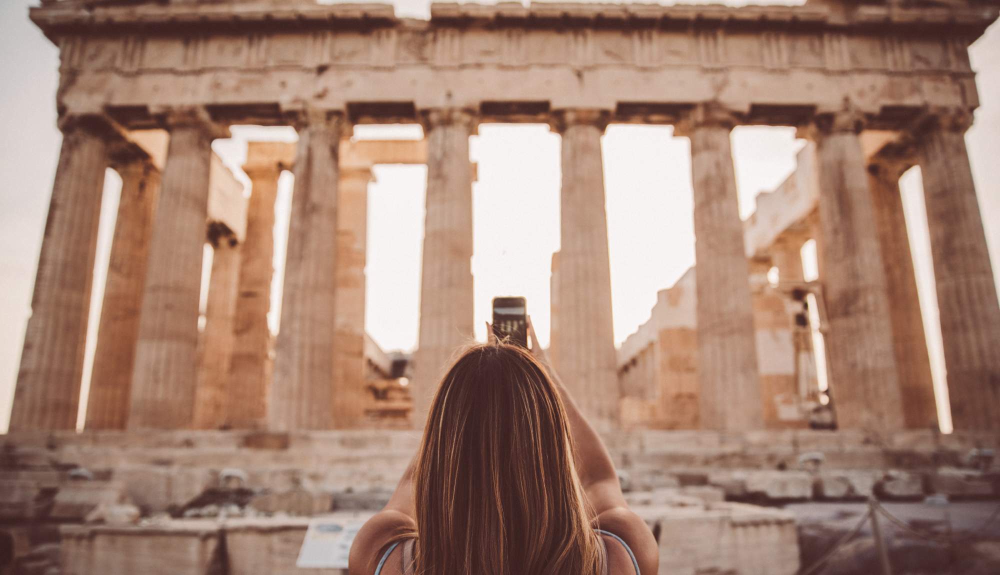 Woman taking a photograph for the Acropolis in Athens after a Celebrity Cruise