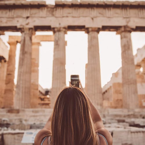 Woman taking a photograph for the Acropolis in Athens after a Celebrity Cruise