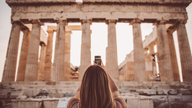Woman taking a photograph for the Acropolis in Athens after a Celebrity Cruise