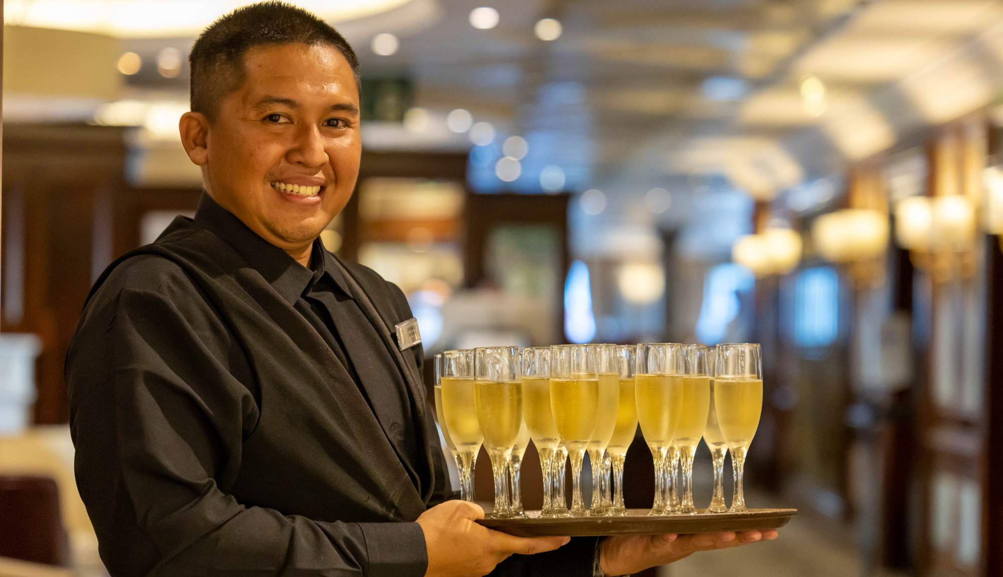 Waiter serving champagne onboard Azamara