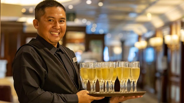 Waiter serving champagne onboard Azamara