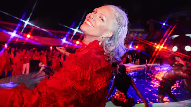 Lady dressed in red enjoying Scarlet Night onboard Virgin Voyages