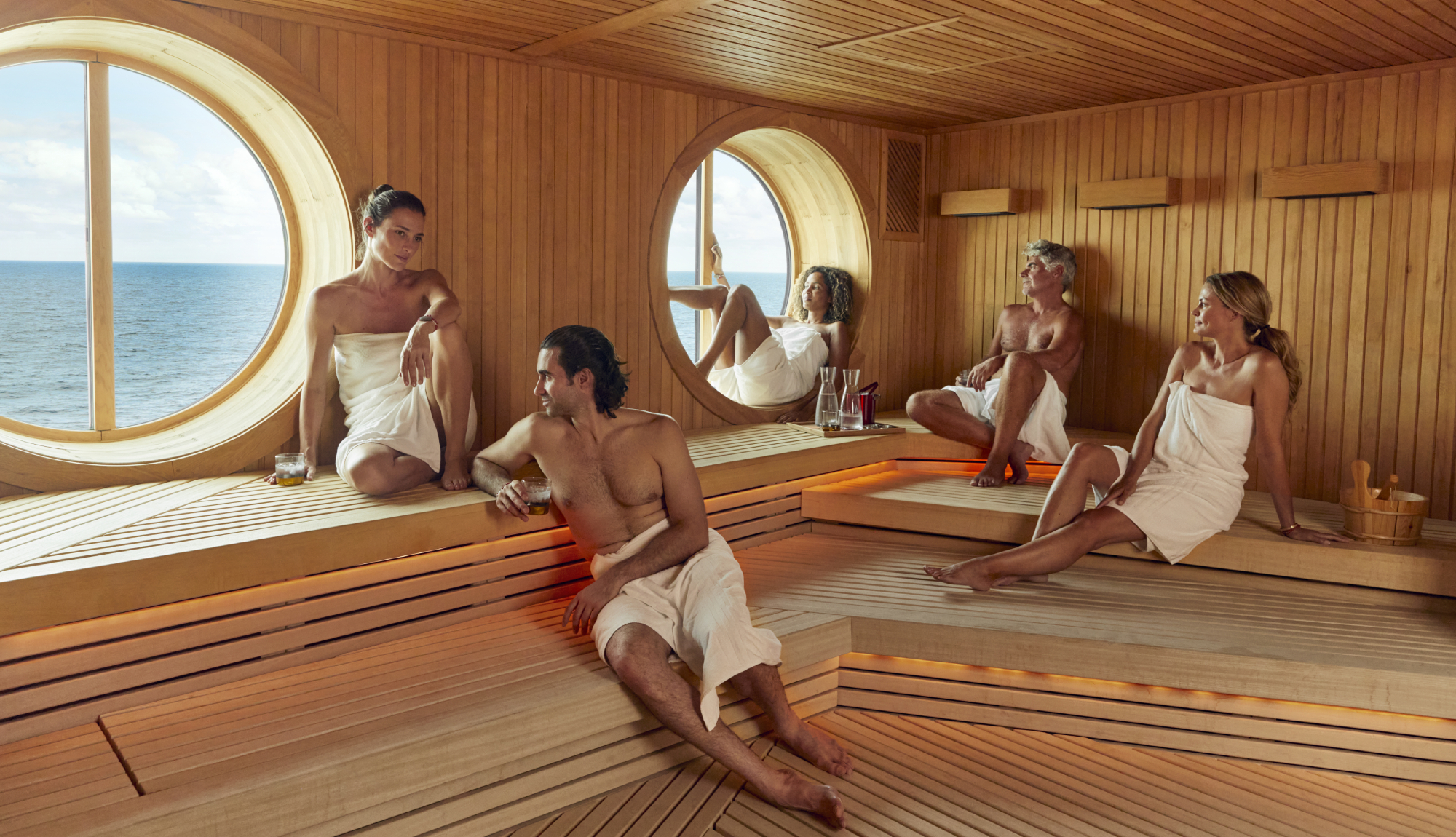 Group of people relaxing in the sauna at the Redemption Spa onboard Virgin Voyages