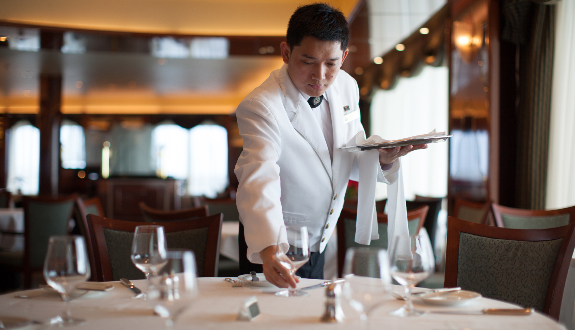 Waiter laying the table onboard Cunard