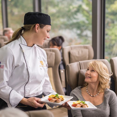 Guests in a SilverLeaf carriage onboard Rocky Mountaineer being served lunch.