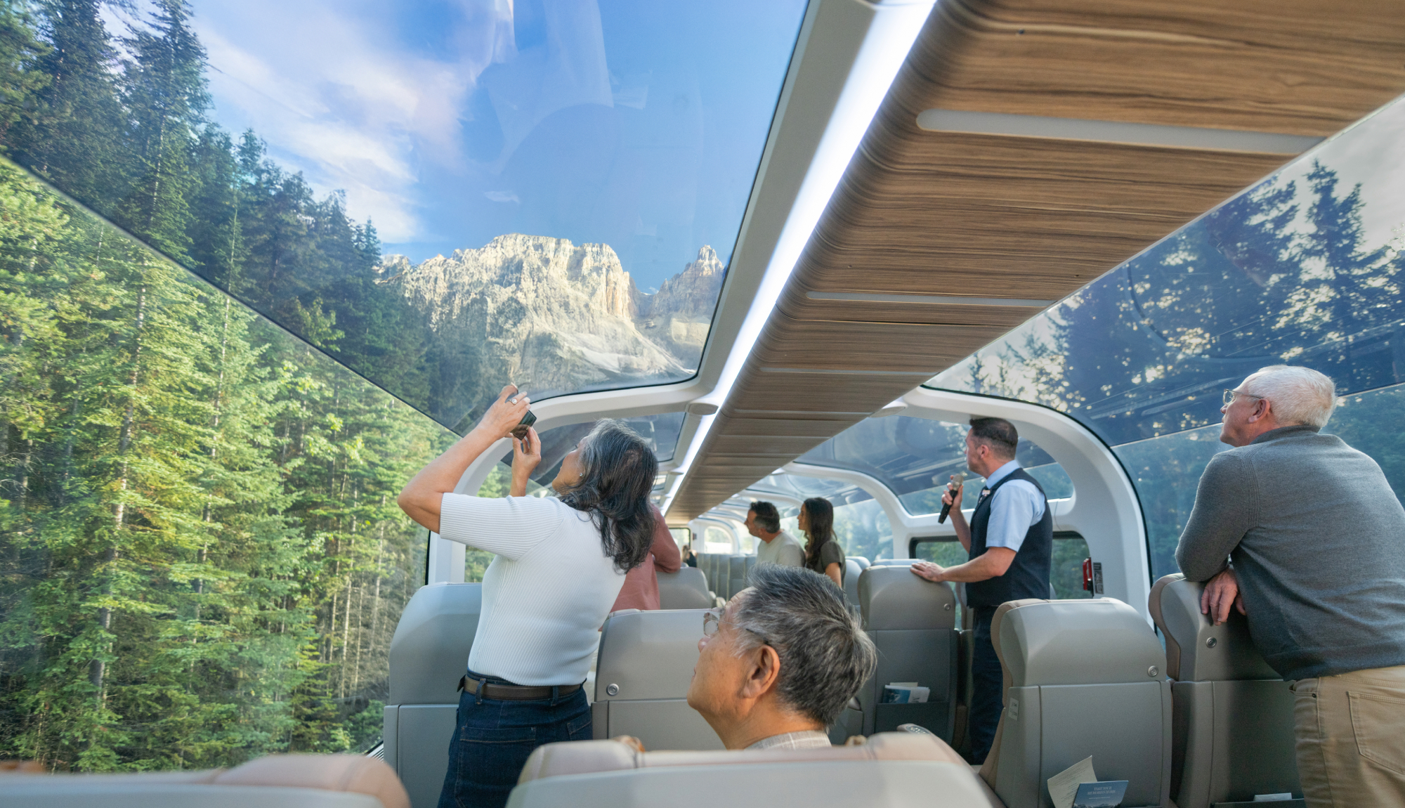 Guests in a GoldLeaf carriage onboard Rocky Mountaineer enjoying the scenery.