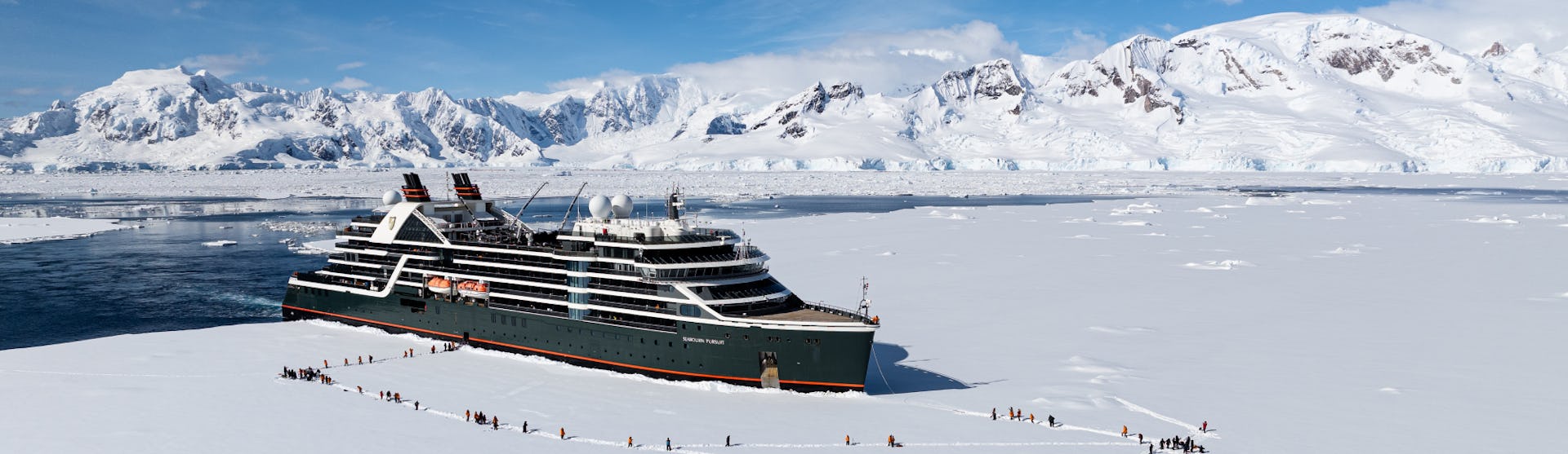 Seabourn Pursuit in Antarctica with guests landing on ice as part of an excursion.