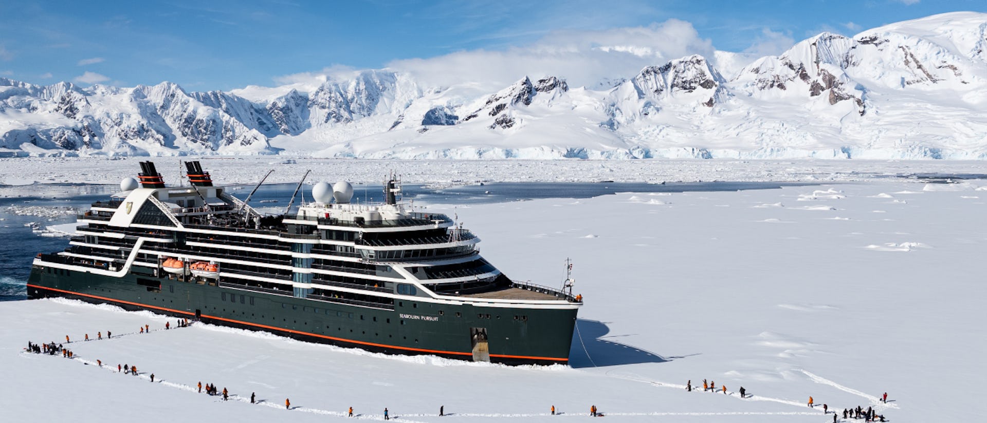 Seabourn Pursuit in Antarctica with guests landing on ice as part of an excursion.