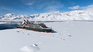 Seabourn Pursuit in Antarctica with guests landing on ice as part of an excursion.