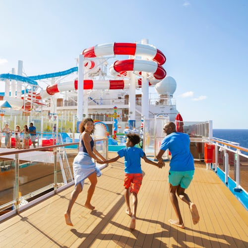 Family running towards waterslides onboard a Carnival ship