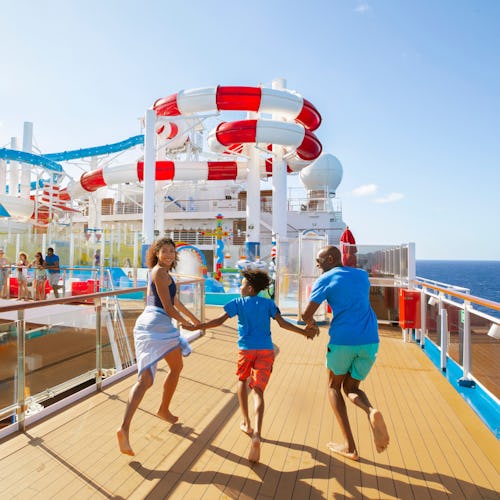 Family running towards waterslides onboard a Carnival ship
