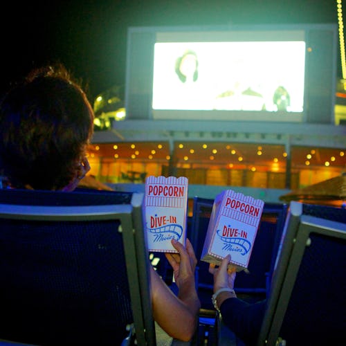 Two people enjoying popcorn and a movie under the stars