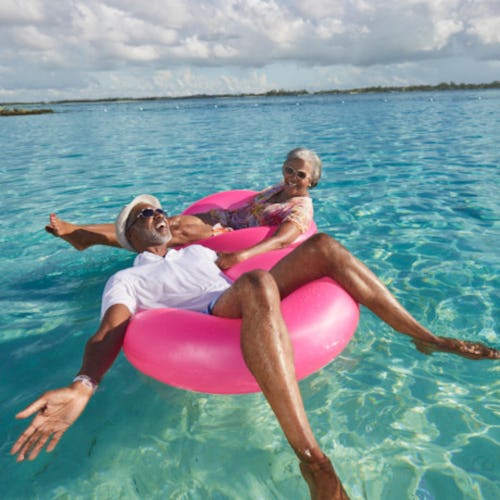 Couple enjoying floating in the ocean on pink inflatables