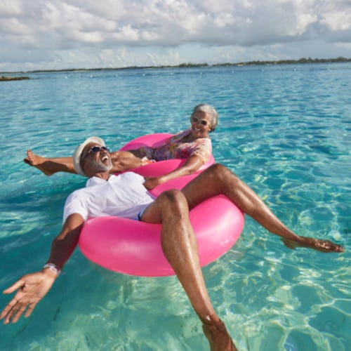 Couple enjoying floating in the ocean on pink inflatables