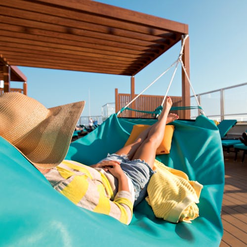 Woman relaxing on a hammock in the adult-only serenity onboard a Carnival ship.