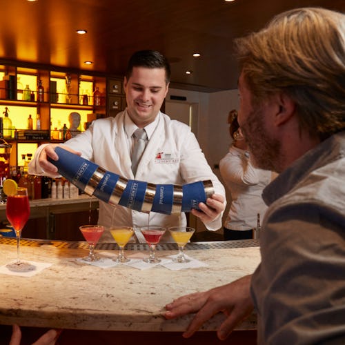 Couple being served colourful drinks at Alchemy Bar