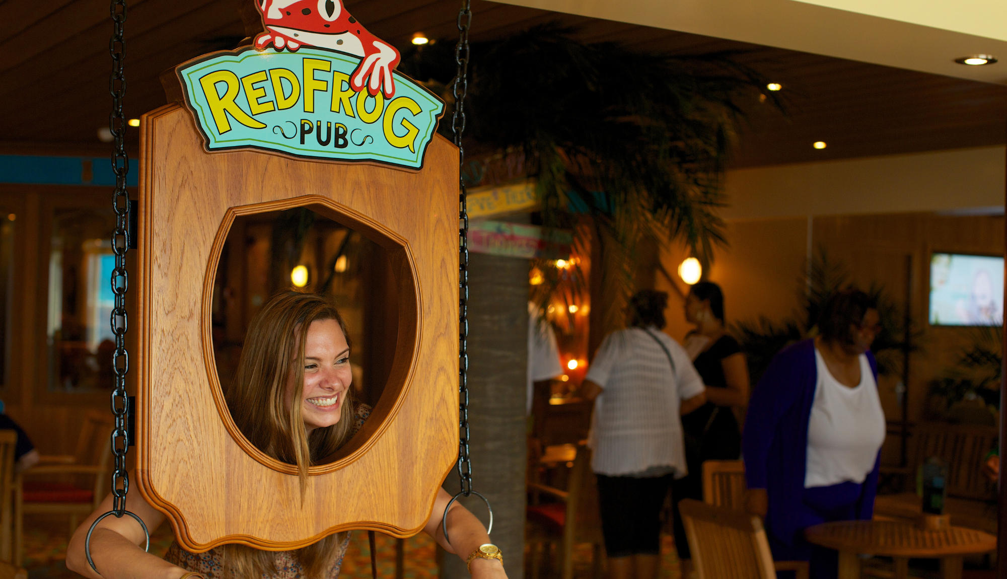 Woman posing with the Red Frog Pub sign