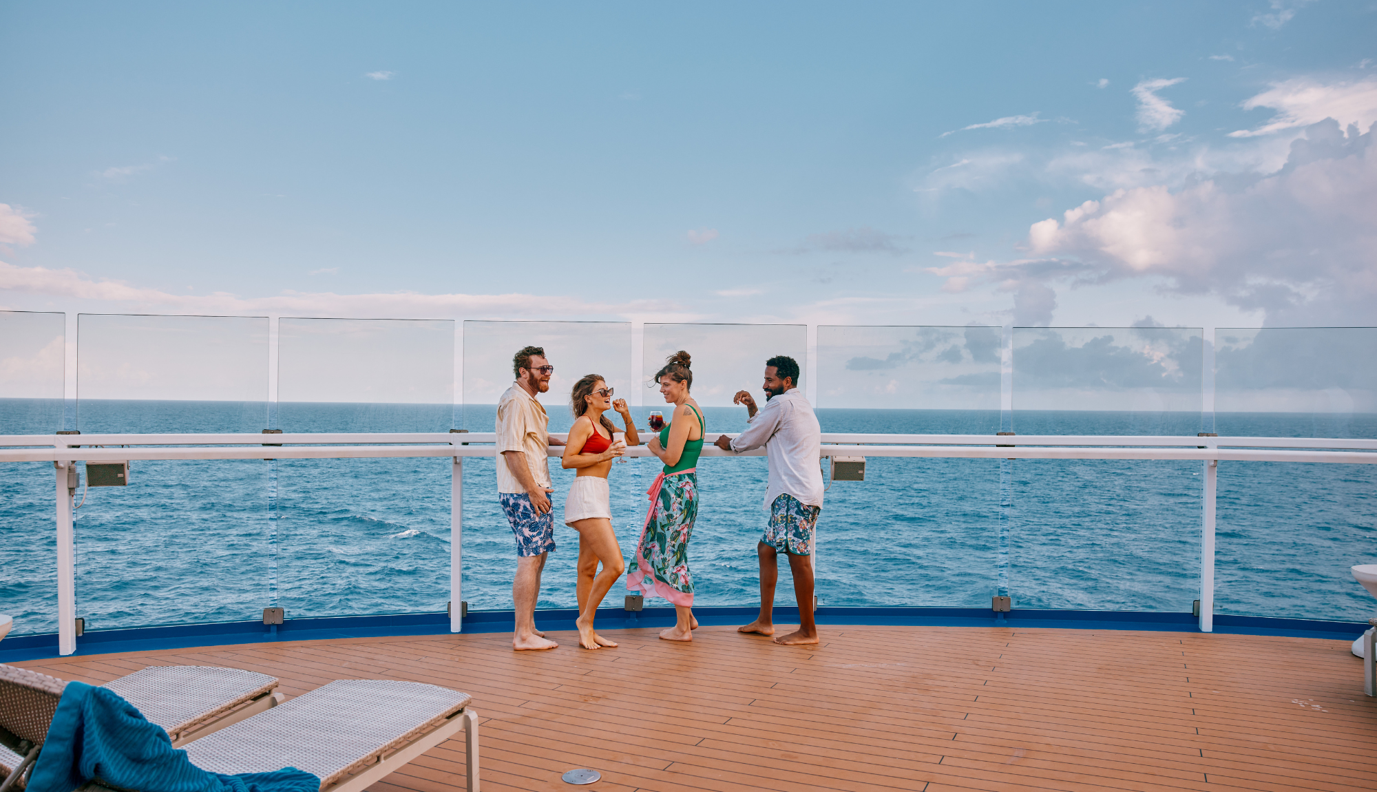 Group of friends enjoying a drink and looking out to sea