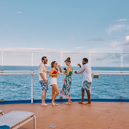 Group of friends enjoying a drink and looking out to sea