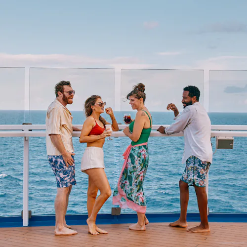 Group of friends enjoying a drink and looking out to sea