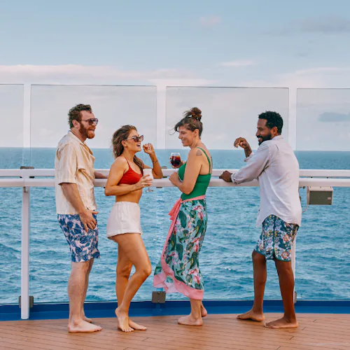 Group of friends enjoying a drink and looking out to sea