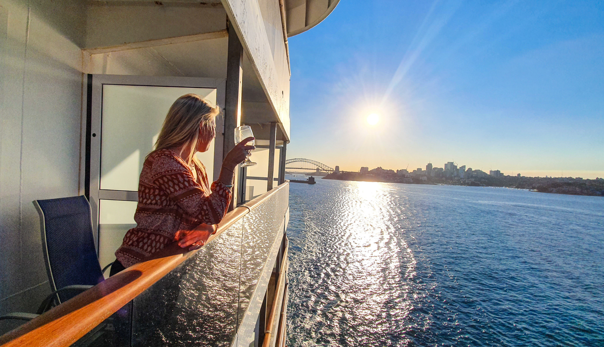 Woman standing on her balcony looking out over the ocean