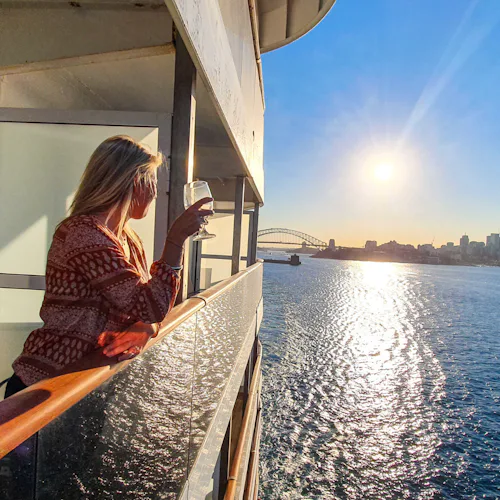 Woman standing on her balcony looking out over the ocean