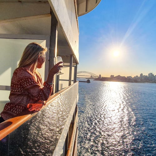 Woman standing on her balcony looking out over the ocean