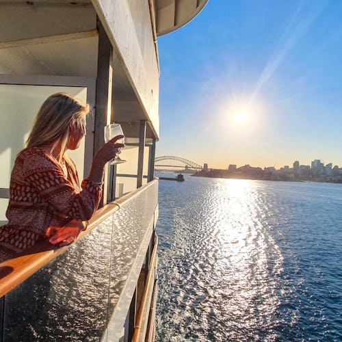 Woman standing on her balcony looking out over the ocean